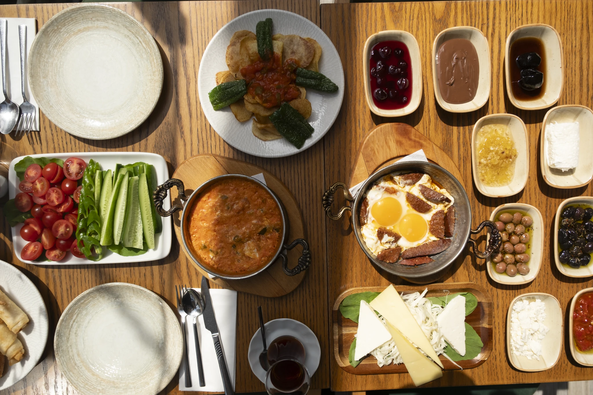 Turkish breakfast spread at Cafe Firuz: eggs in a copper pan, menemen, cheeses, jams and olives