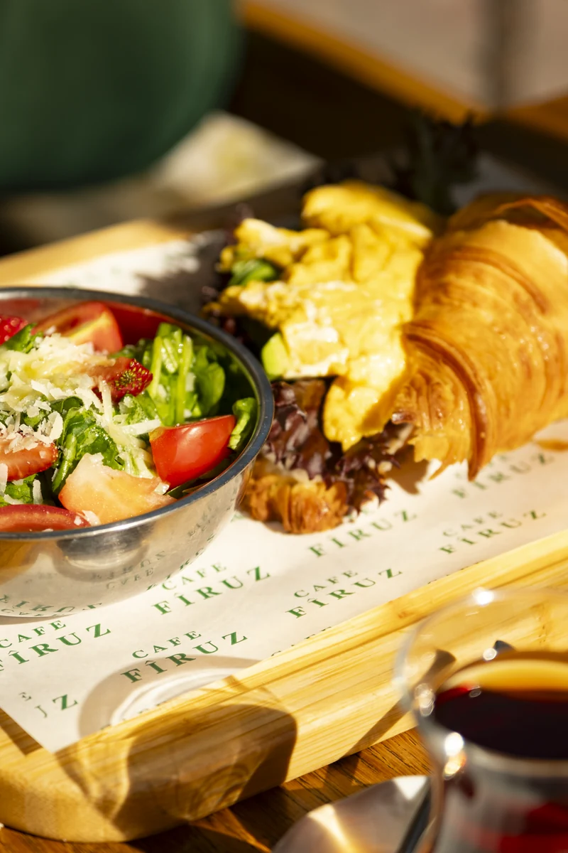Avocado croissant sandwich with a side salad