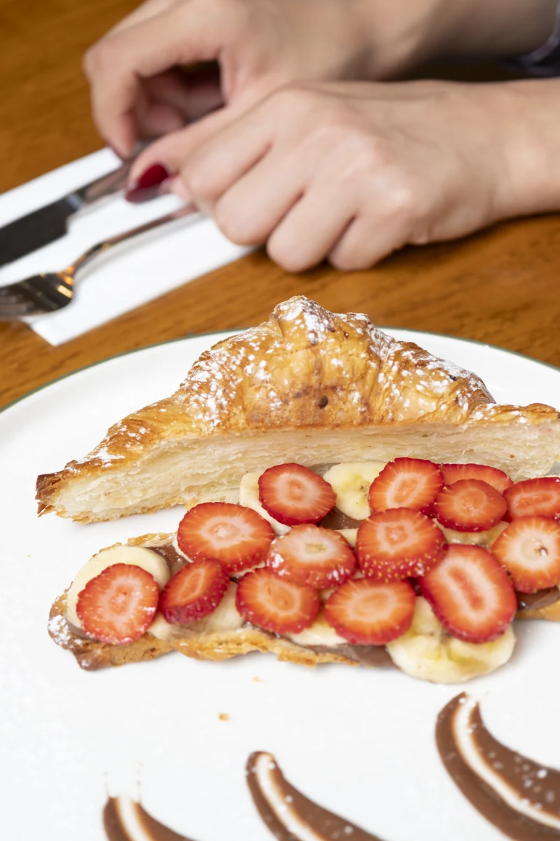 Sweet croissant with strawberries and banana